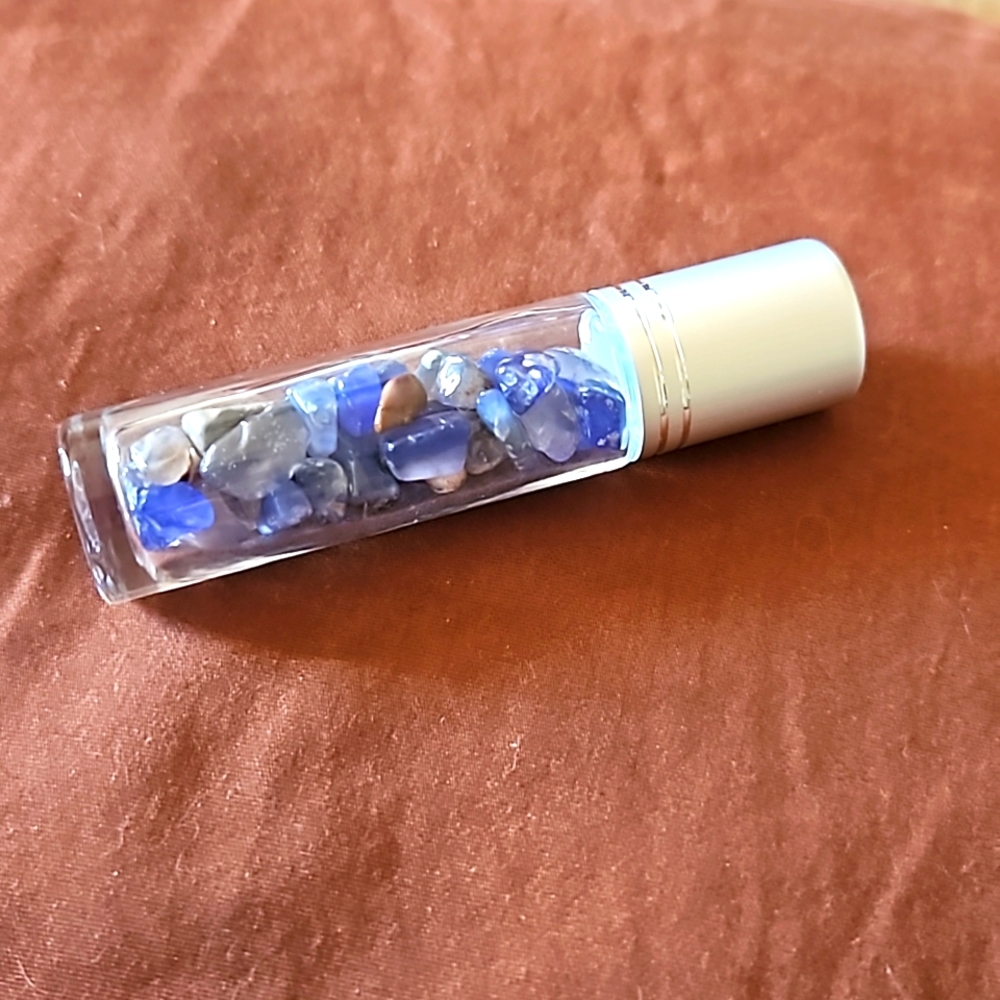 Empty glass roll on bottle with Blue Agate chips inside